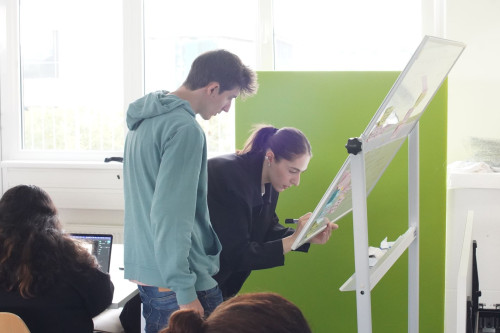 Participants of the Intensive I Living Labs writing on a whiteboard.