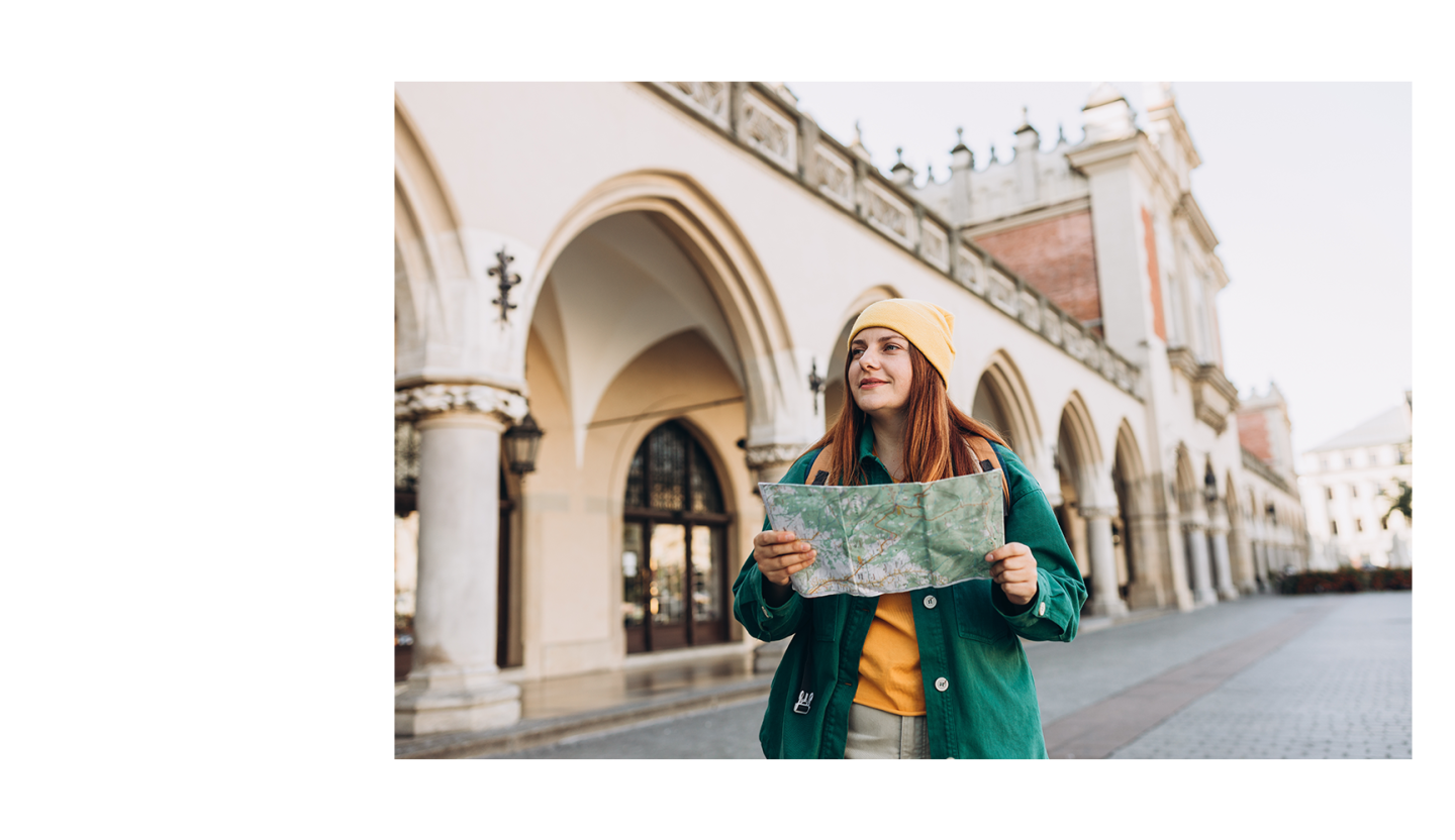 young woman with a backpack and a map standing outside.